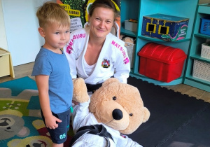 Wspólne zdjęcie chłopca z trenerką Judo i maskotką misiem