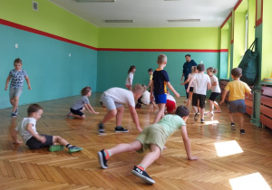 Dzieci wykonują ćwiczenia na sali gimnastycznej